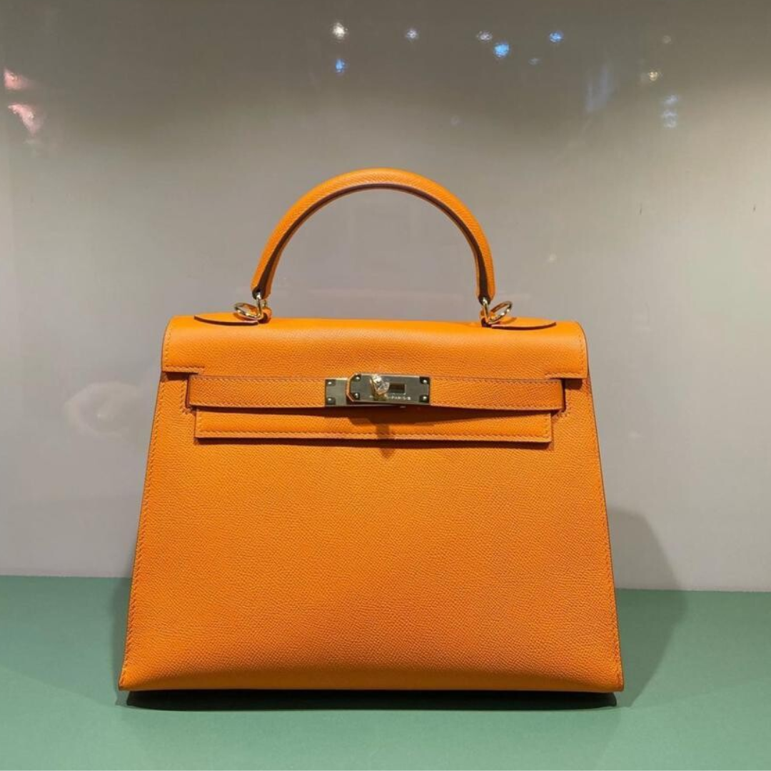 HERMÈS KELLY 25 TASCHE MIT GOLDENEN BESCHLÄGEN IN ORANGE